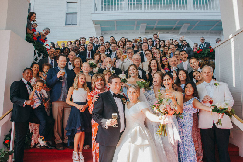 every wedding guests got together for a photo on the red carpeted stairway at the Grand Hotel on Mackinac Island