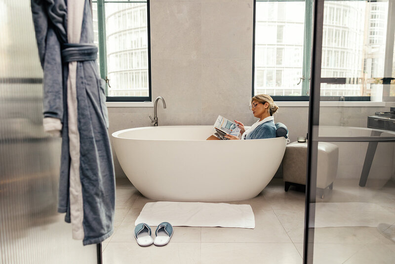 A female entrepreneur standing in a modern, styled workspace, leading a brainstorming session on business growth with a whiteboard, smiling confidently.