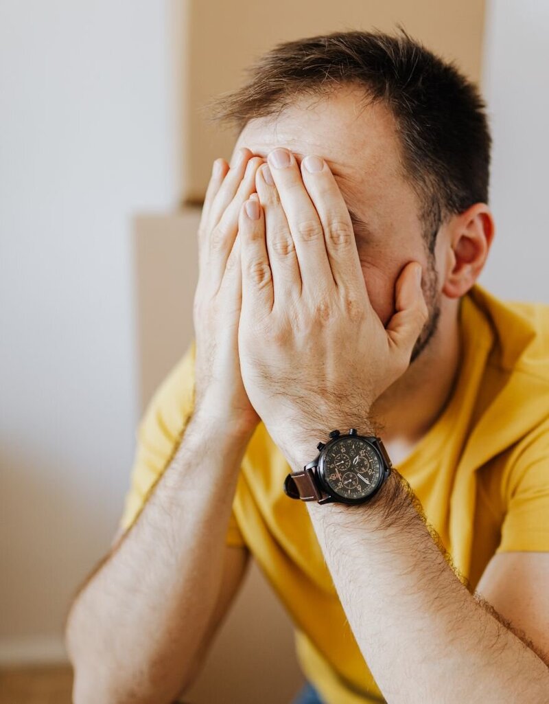 A man with his hands on his face looking frustrated represents the frustration after infidelity and the hope betrayed partners can get from The Affair Recovery Program: It's Okay To Stay by Relationship Experts offering a roadmap to healing and rebuilding trust to couples in the aftermath of infidelity in the United States, Canada, and globally.
