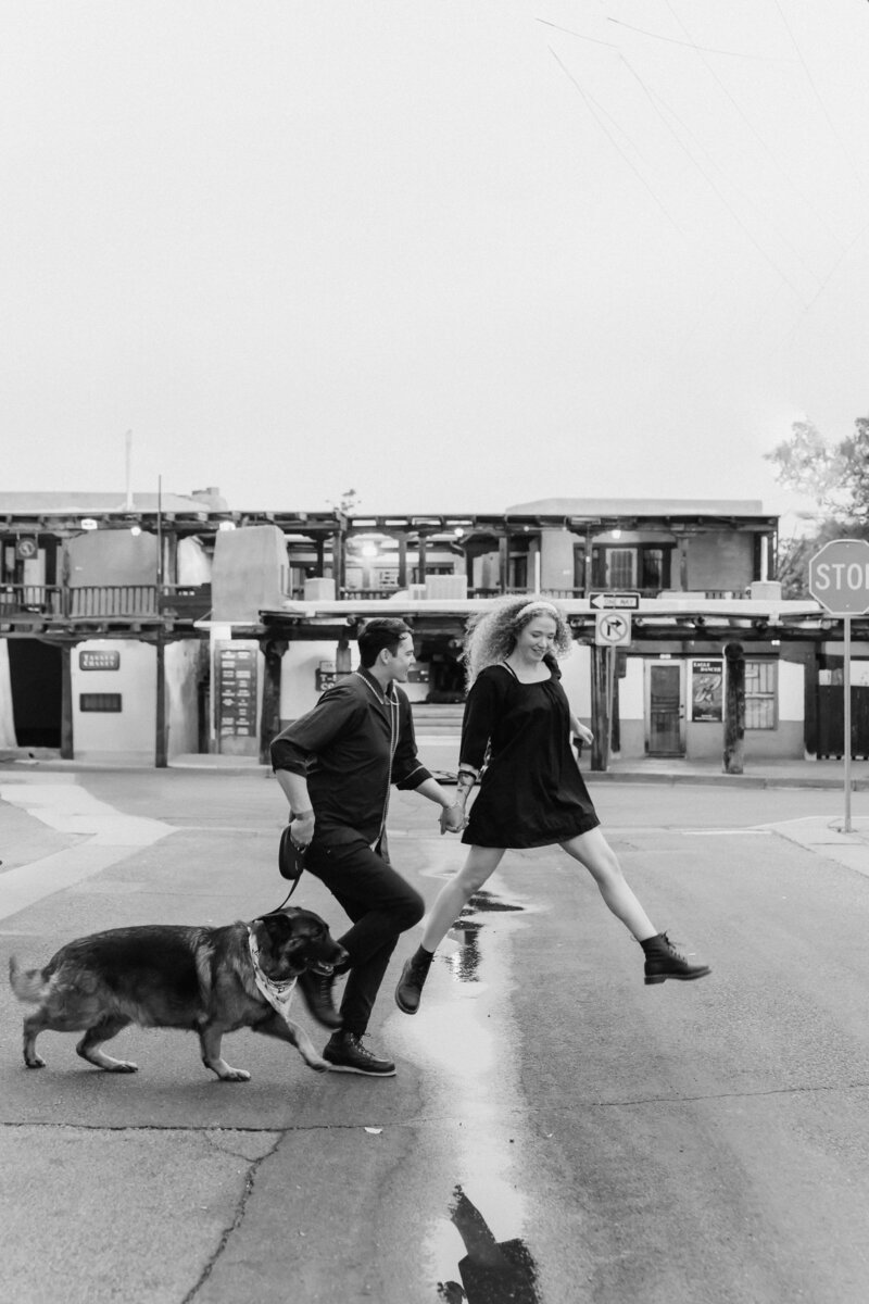 Couple jumping over a puddle during their engagement session