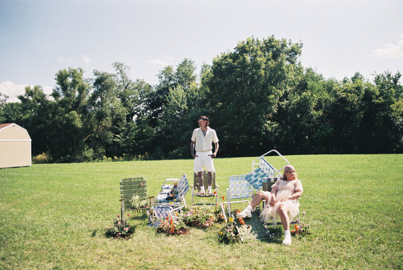 A couple outdoors in picnic chairs, representing a styled photoshoot by Among the Oaks. 