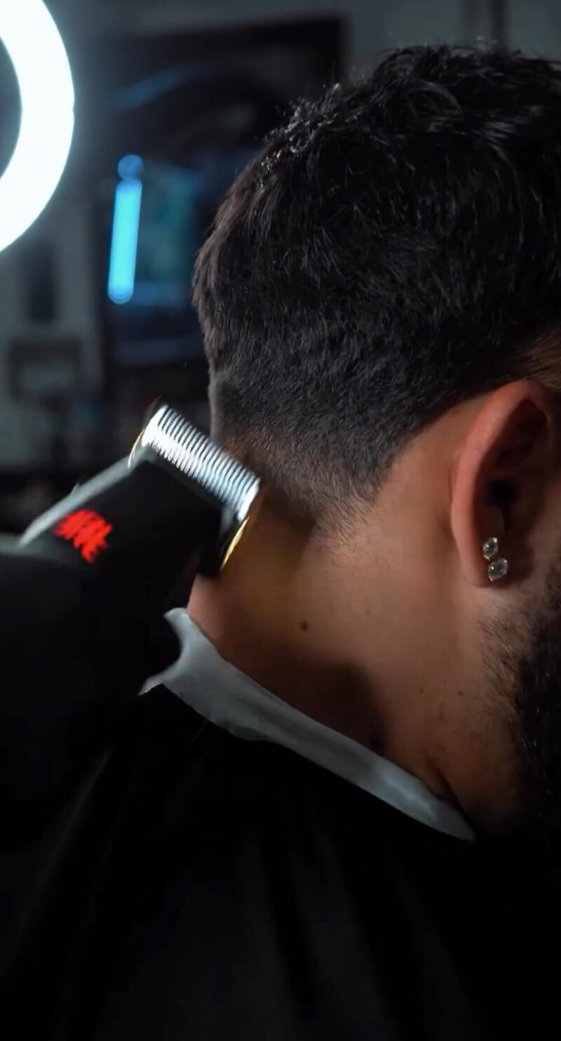 A close up shot of a barber using clippers at Onyx Barbershop in Wildomar, California.