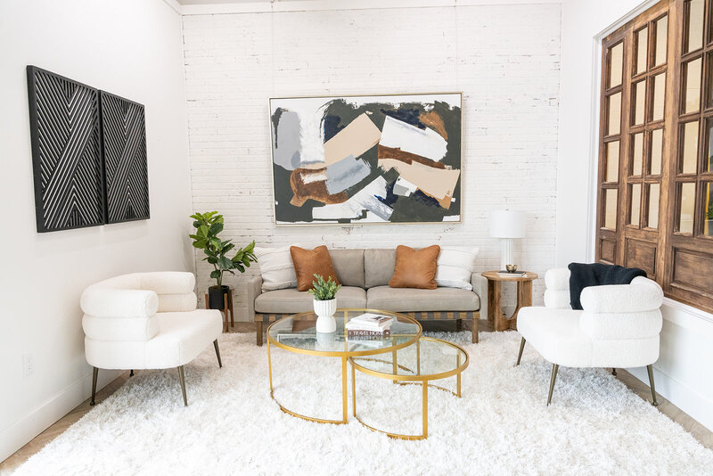 living room with couch, 2 white chairs, white, gold, black accents