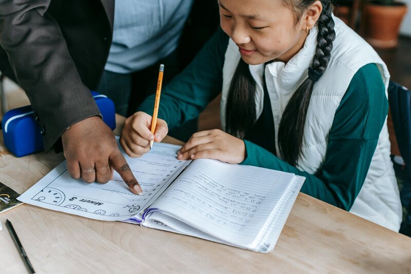 student getting help on an assignment in her workbook