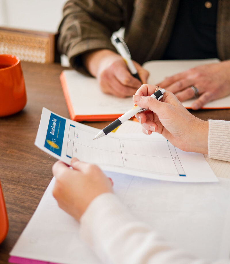Two people at table discussing and looking at documents