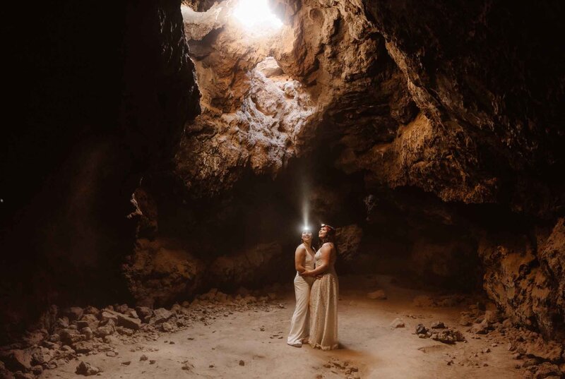 Couple lookin towards sunlight in a Mojave Lava Tubes cave