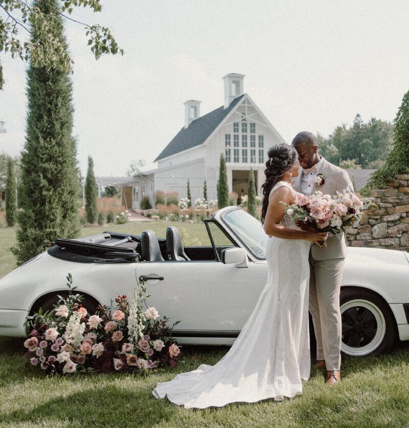 bride-and-groom-touching-heads-in-front-of-car