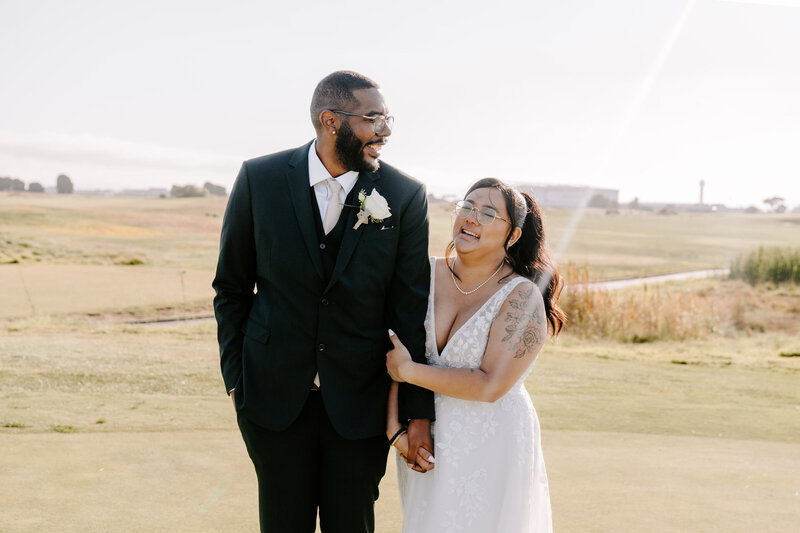 newlyweds walking in field