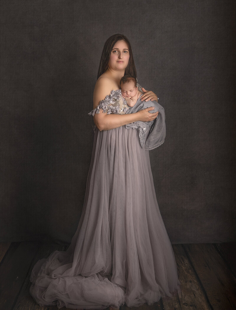  "A beautiful moment of a mother cuddling her newborn baby while wearing an elegant couture gown, captured in a timeless and graceful family portrait at Sonia Gourlie Fine Art Photography in Ottawa."