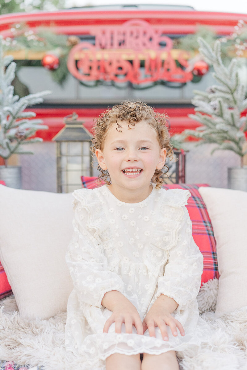 close up of girl smiling during red truck mini session in Loudoun County, Virginia