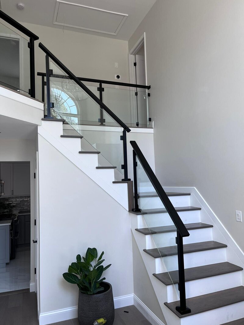 Modern looking railings with black glass posts and handrails.