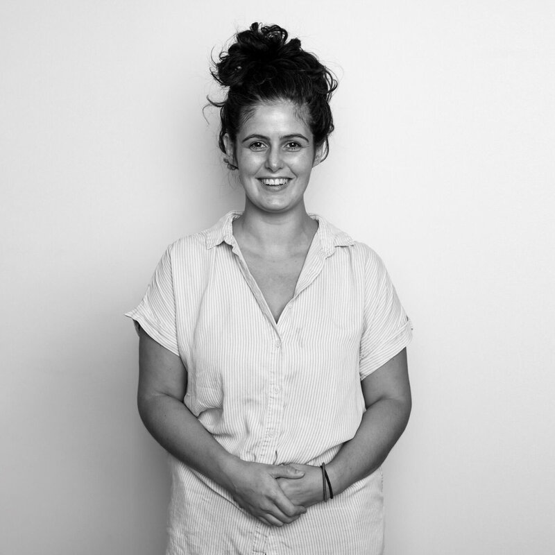 Black and white before shot of a woman in a white blouse, confident smile.