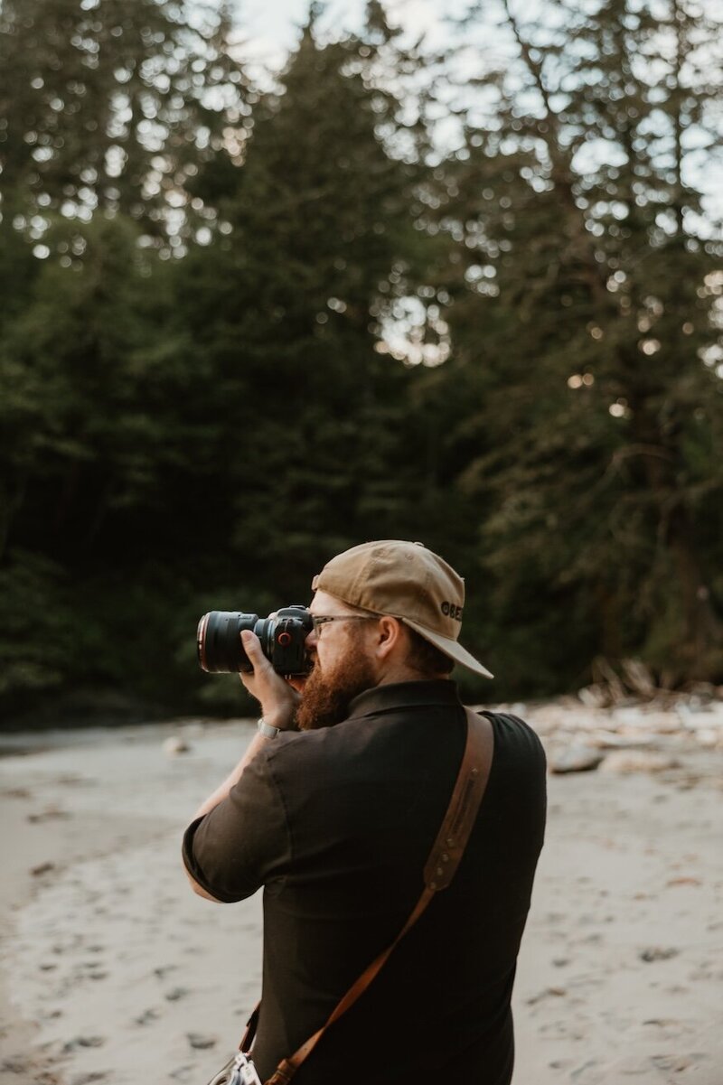 Hunter Wickert wearing his camera gear at the Oregon Coast while he takes a perfect shot of a couple