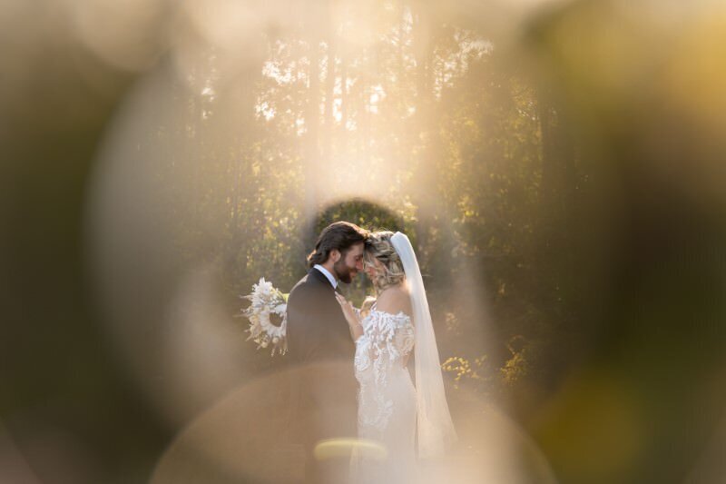 Romantic wedding portrait by St. Augustine wedding photographer showing bride and groom in an intimate moment with dreamy sparkling bokeh lights creating a magical atmosphere