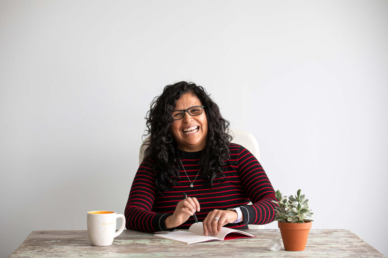 woman at desk with notebook and smiling