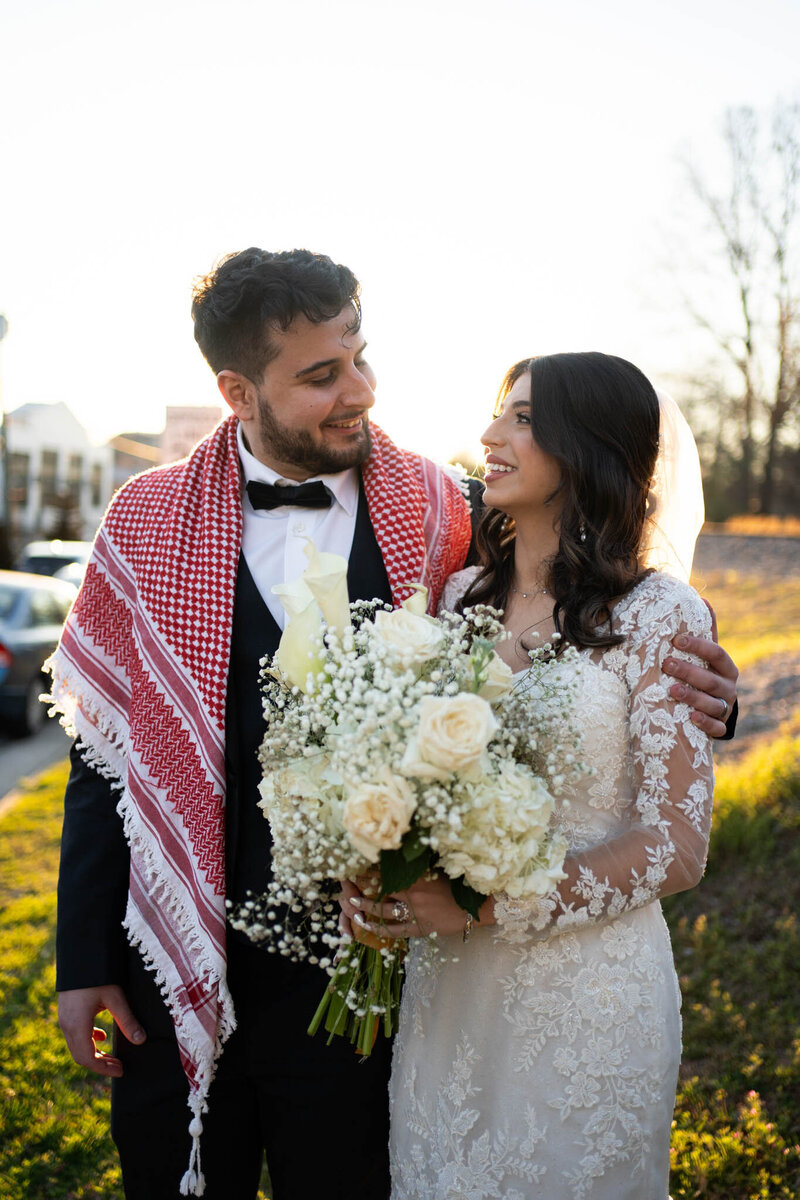Couple smiling with bouquet and keffiyeh