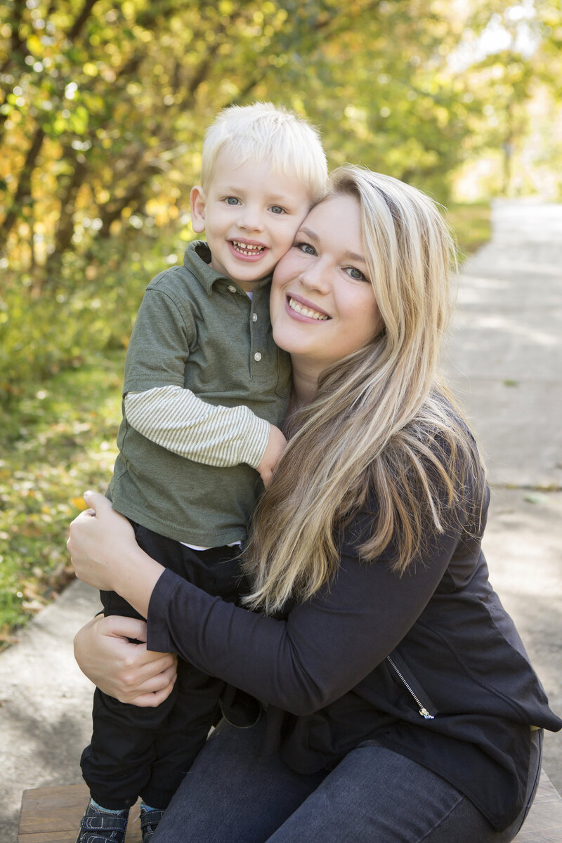 mom hugging son and smiling at camera