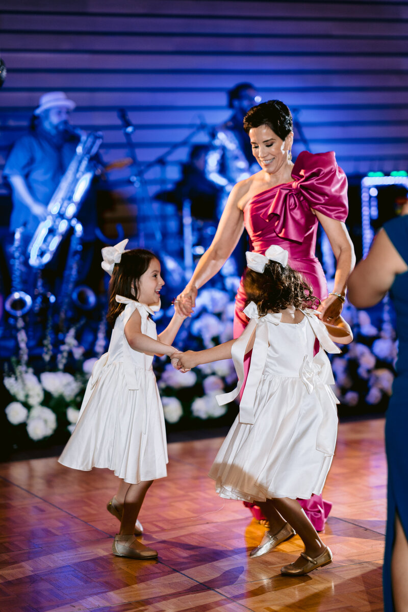 lady in pink dress dances with children
