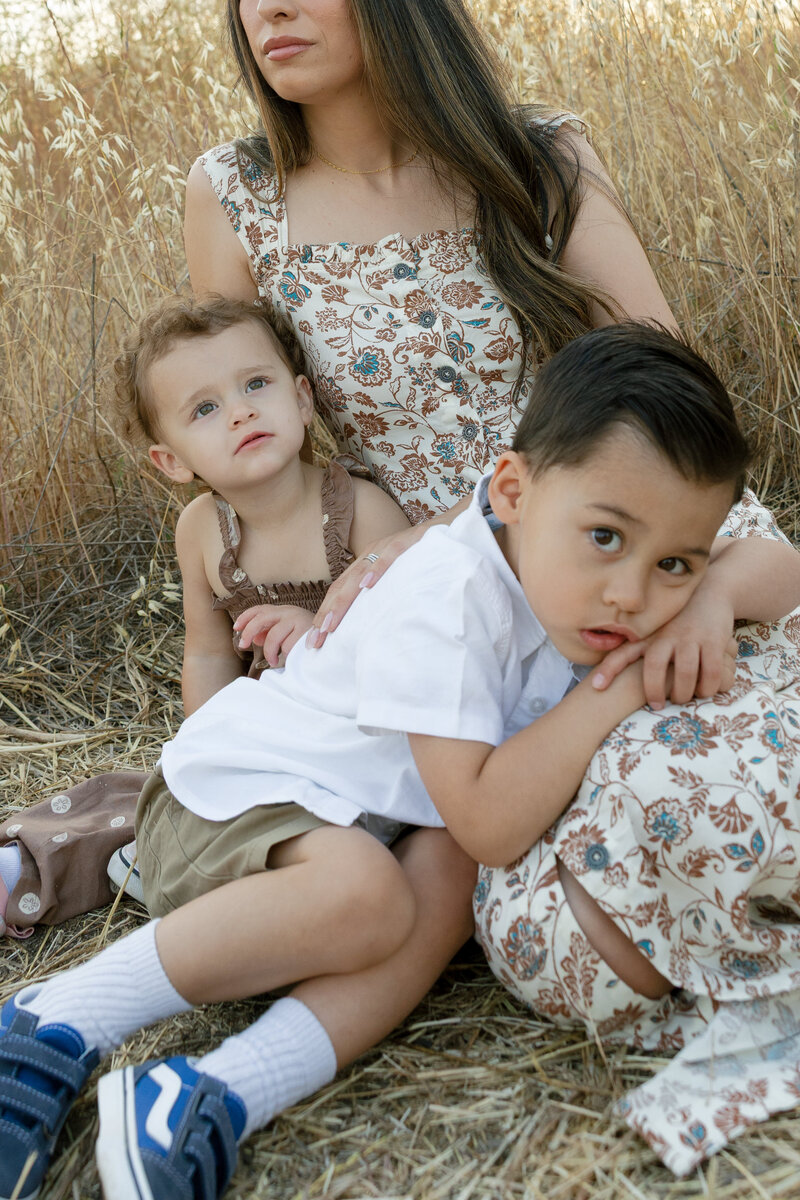 A boy with his head in moms lap while the little girl looks off for a family photo in New Braunfels. 
