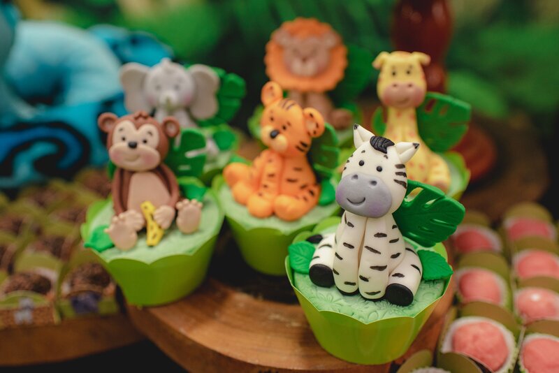 A selection of cupcakes decorated with cute jungle animals for a kids' party.