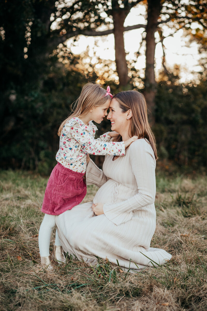 fall field photo of pregnant mother and daughter