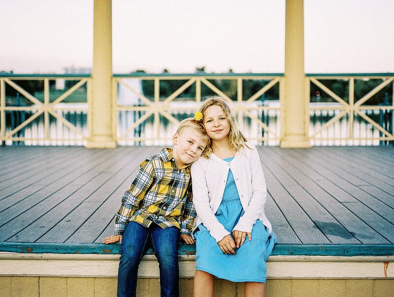 brother and sister with blonde hair pose at a denver park
