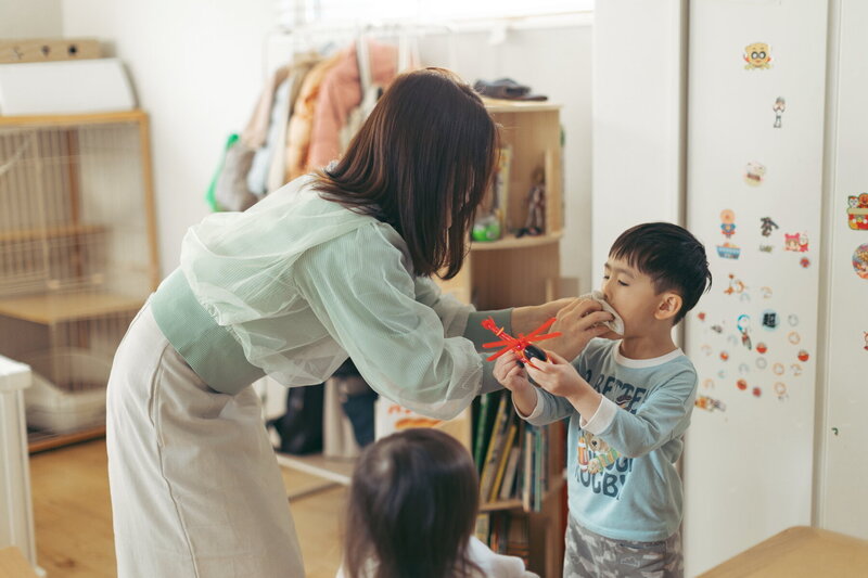 ママが子供の顔を拭いてあげている日常の写真