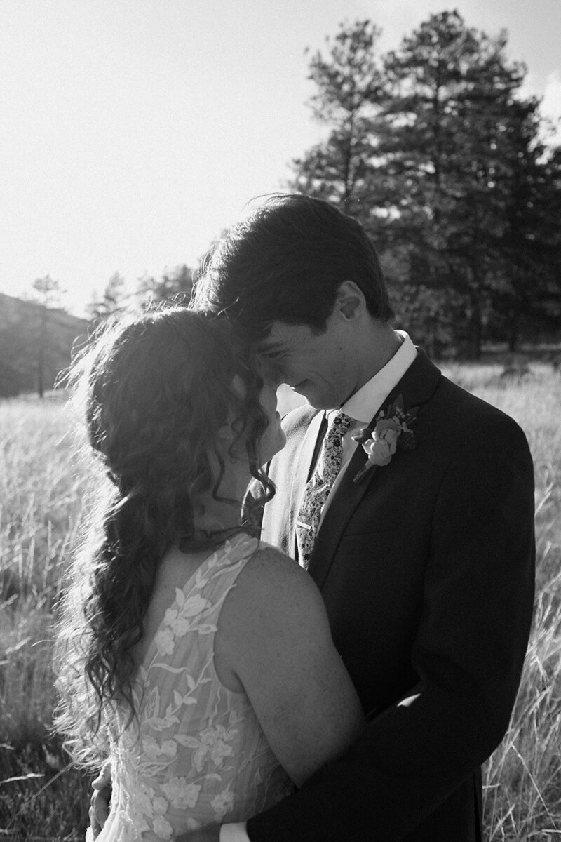 bride and groom embrace at sunset at Deer Creek Valley Ranch wedding venue in Colorado