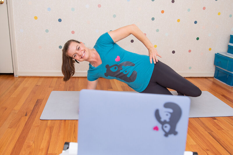 A female physical therapist showing her client how to do a side plank during a virtual physical therapy session.