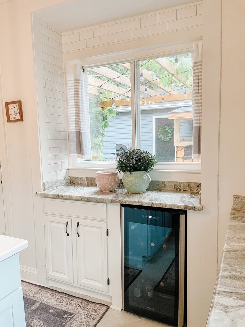 Bright kitchen with white cabinets and a light blue kitchen island.