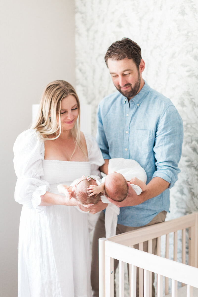 Mom and dad with their twin newborns during an in-home lifestyle newborn session in Denver