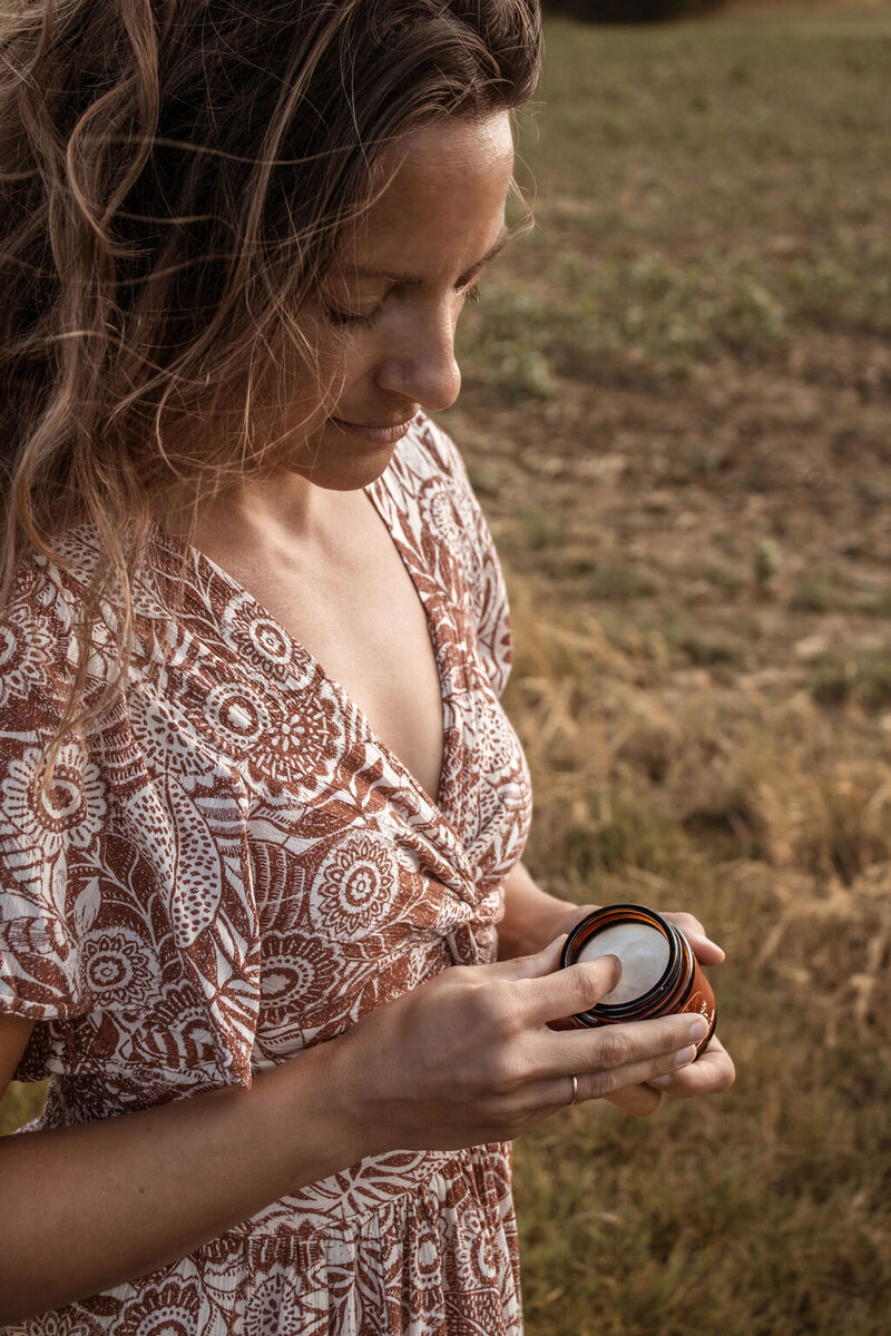 Woman opening naturally infused tallow cream Indiana