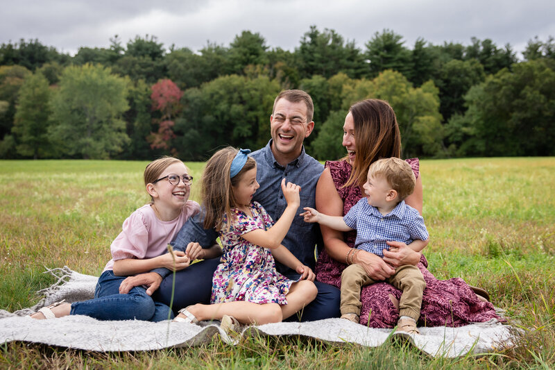 Family sitting together laughing in field