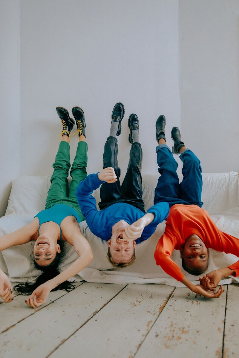 LGBTQ+ kinds laying upside down on a couch and laughing