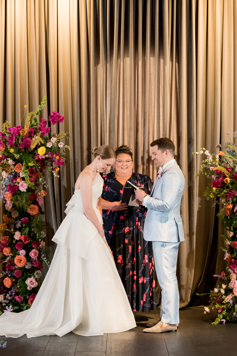 groom reads vows to smiling bride during ceremony