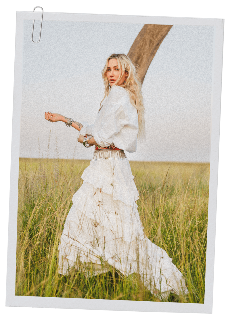 Alexis wearing a white dress standing in field in Africa