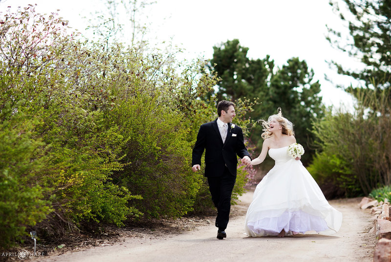 Couple runs along a path on their wedding day at Hudson Gardens