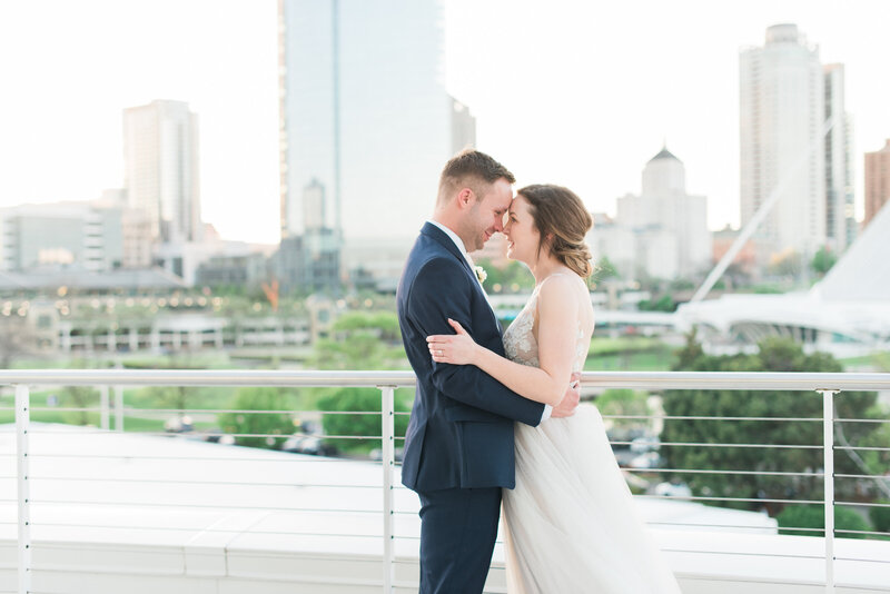 bride and groom hugging during their downtown milwaukee wedding for portraits during sunset at Discovery World in Milwaukee Wisconsin