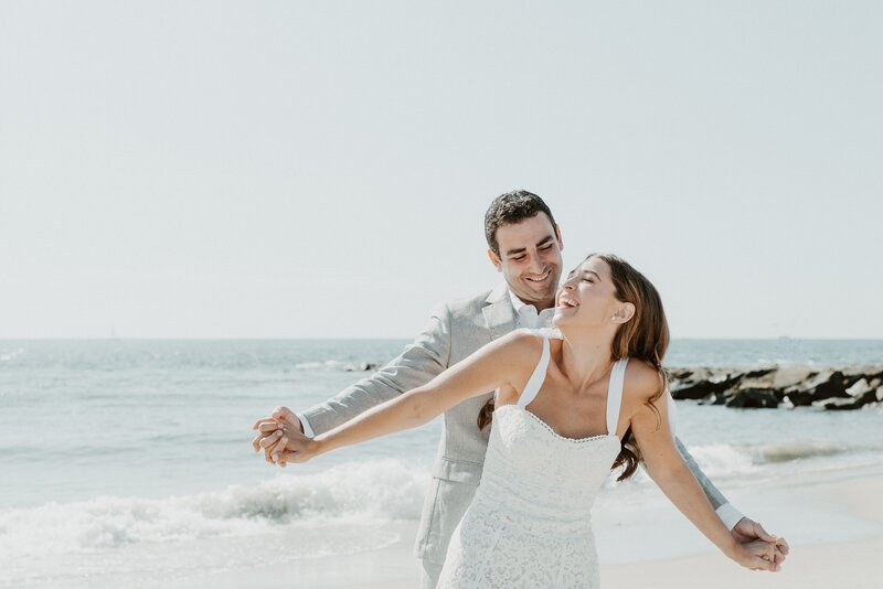 Bride and groom laughing on beach in California at their wedding