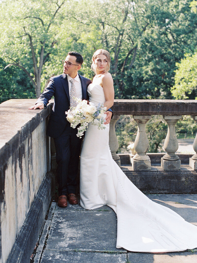 Editorial, fine art image of bride and groom on balcony after St Rocco Catholic Church wedding in Cleveland