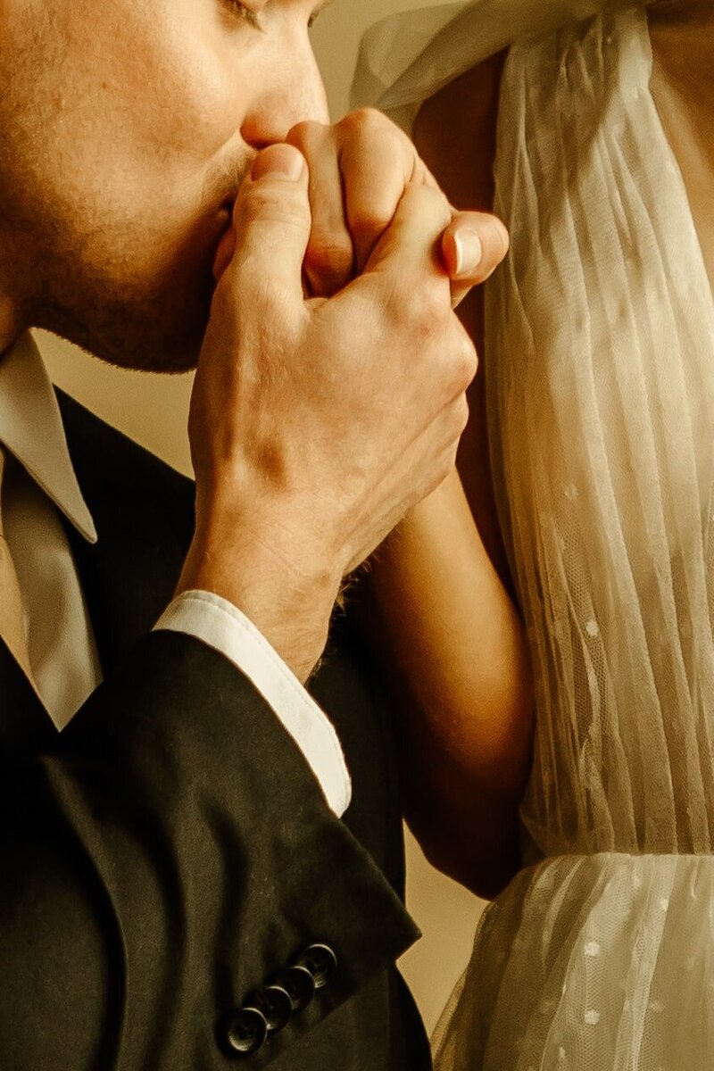 Romantic moment as the groom tenderly kisses the bride's hand.