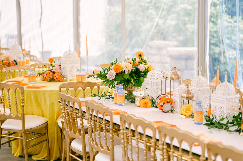orange florals on top of white table for indian wedding