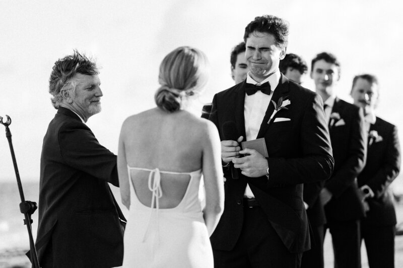 Groom laughs with bride during toasts at Glen Foerd Estate in Philadelphia, PA