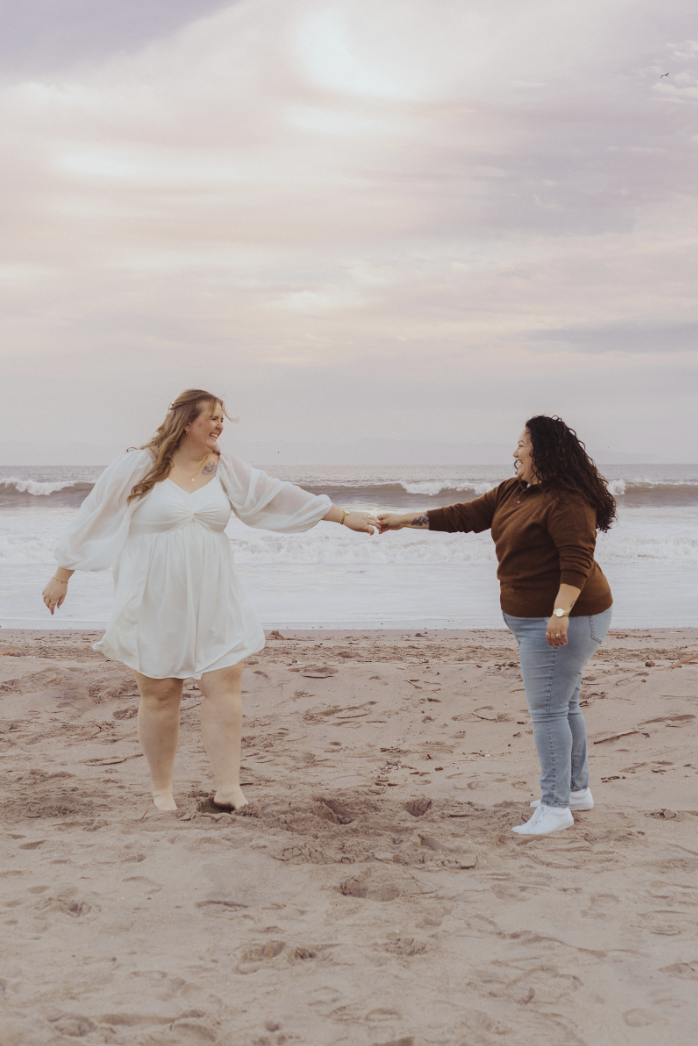 lesbian couple holding hands with a peach tinted filmy editing style