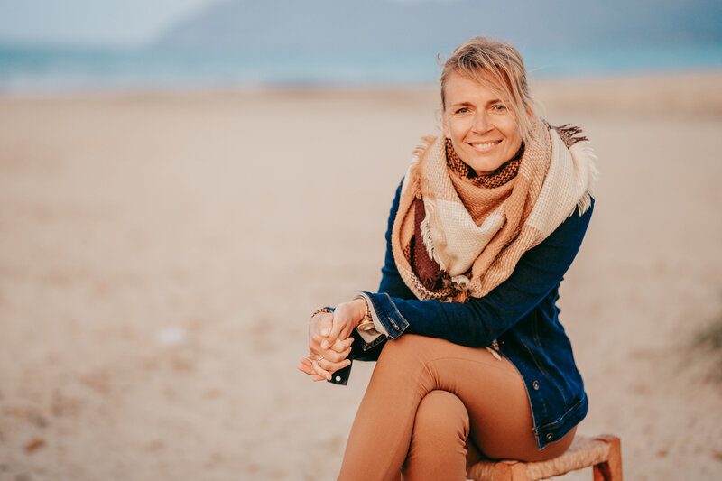 Sylke mit Schal am Strand sitzend