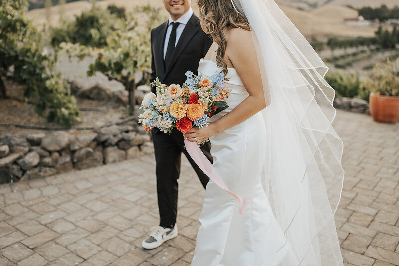 A bride and groom enjoy their wedding flowers.