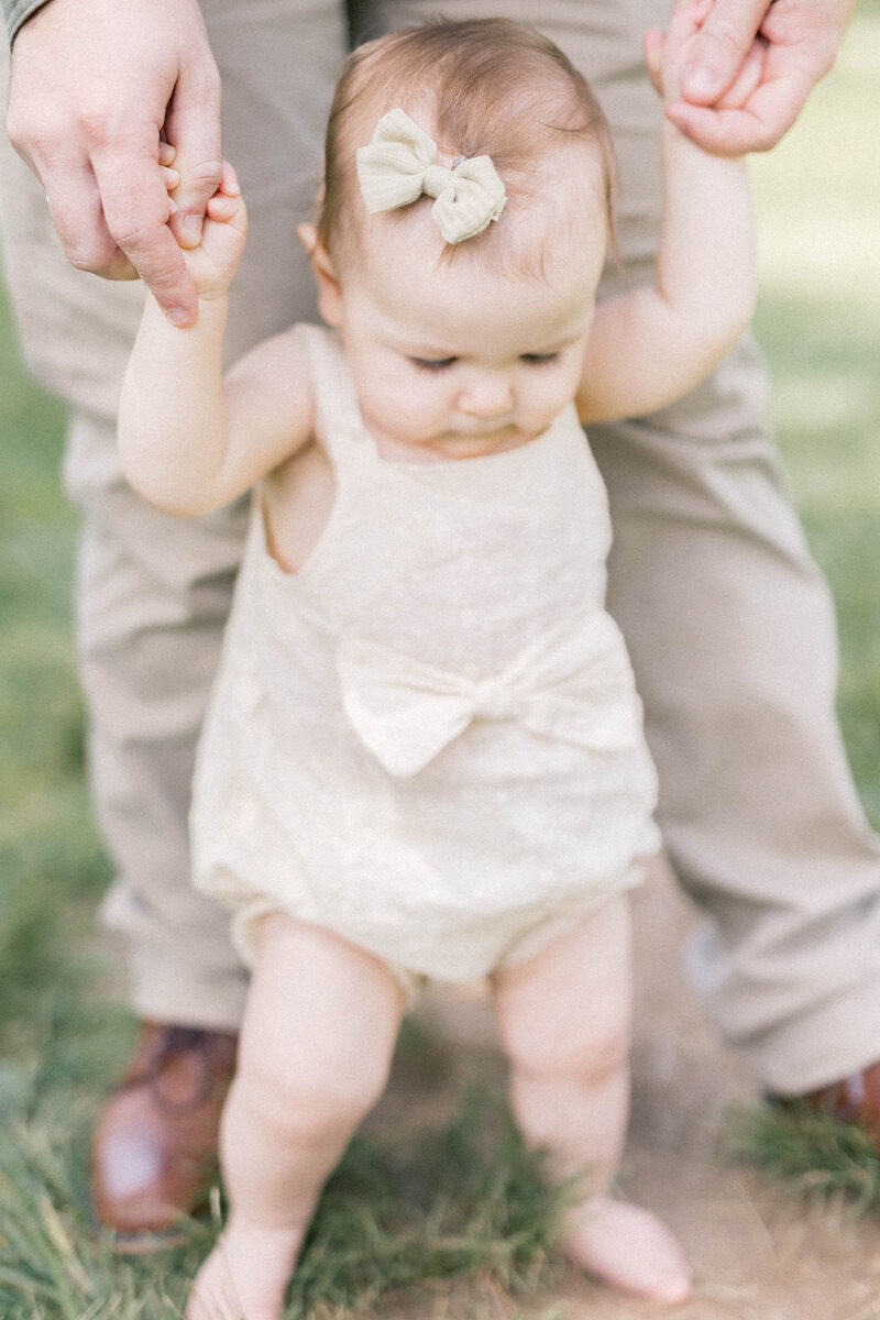 knoxville family photographer dad holding babys hands while baby stands