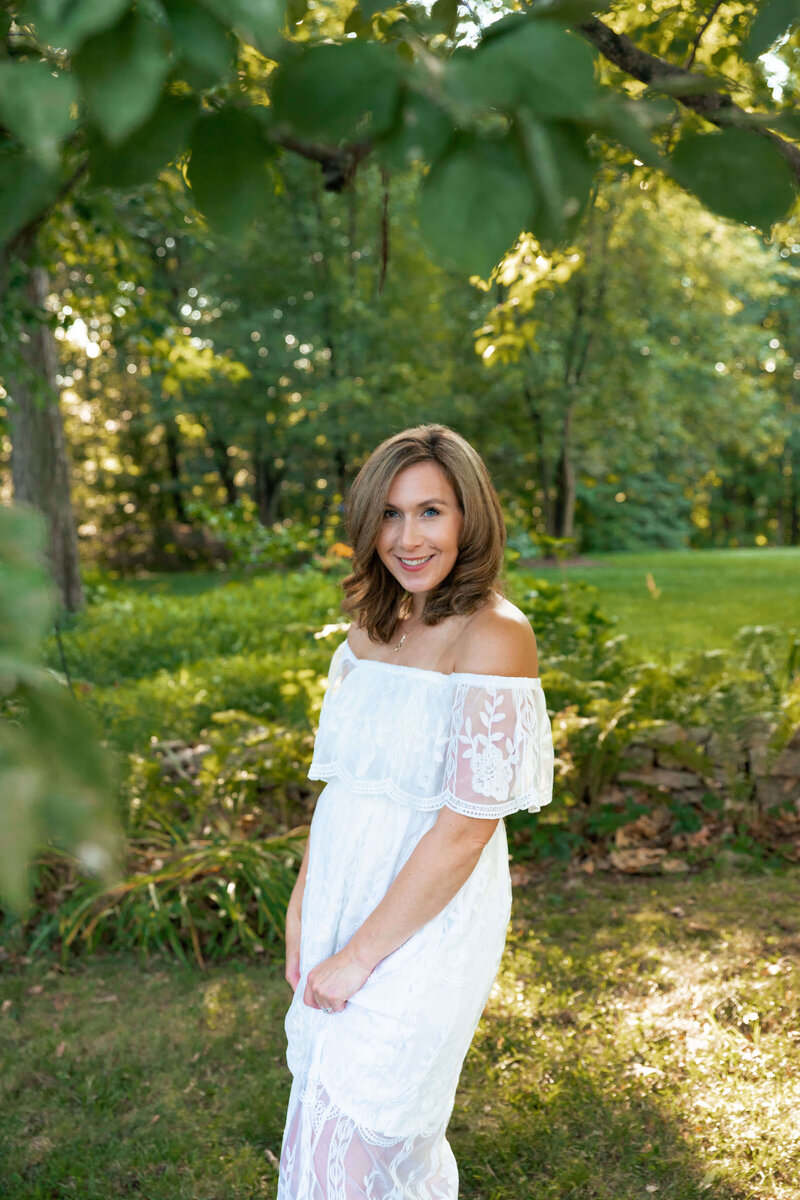 Philadelphia Newbon Photographer standing in a garden in a white dress