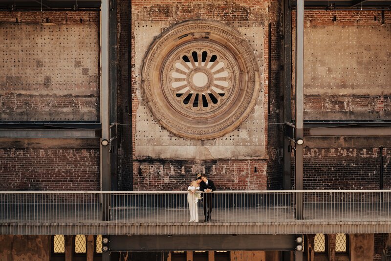 historic building featuring bride and groom leaning over a balcony