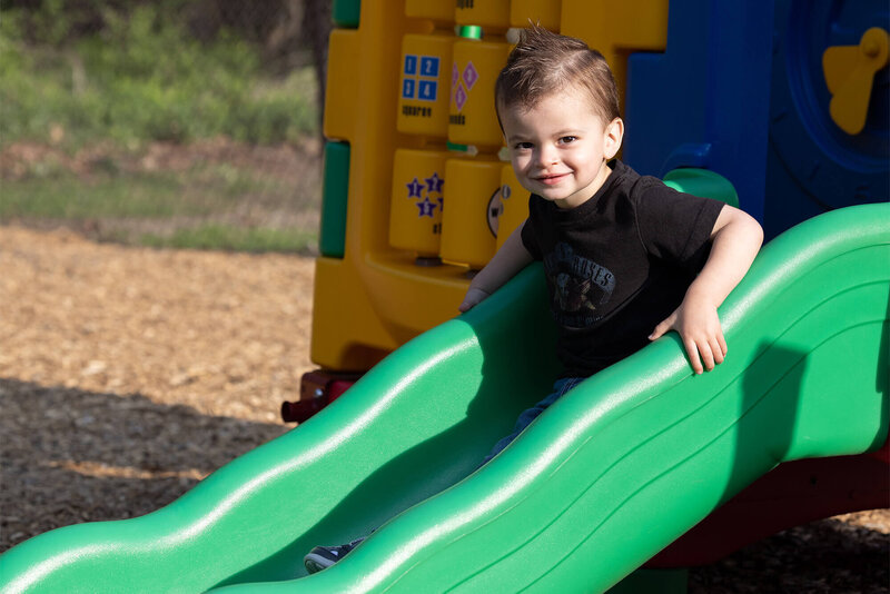 happy toddler going down the slide